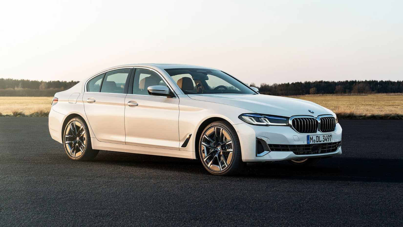 Toma estática de 3/4 del frente de un BMW 540i blanco 2020.