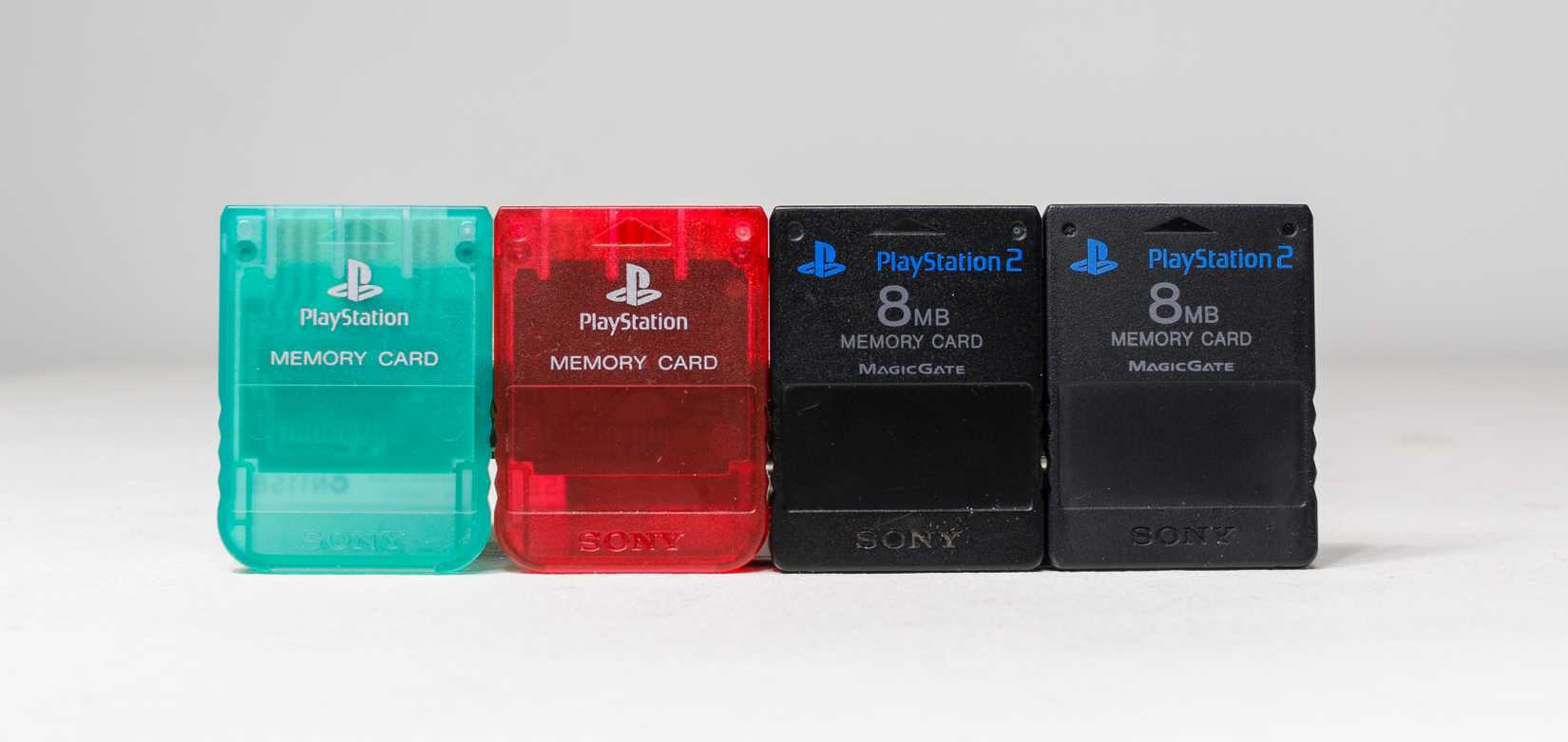 Four PlayStation 2 memory cards side-by-side in various colors.
