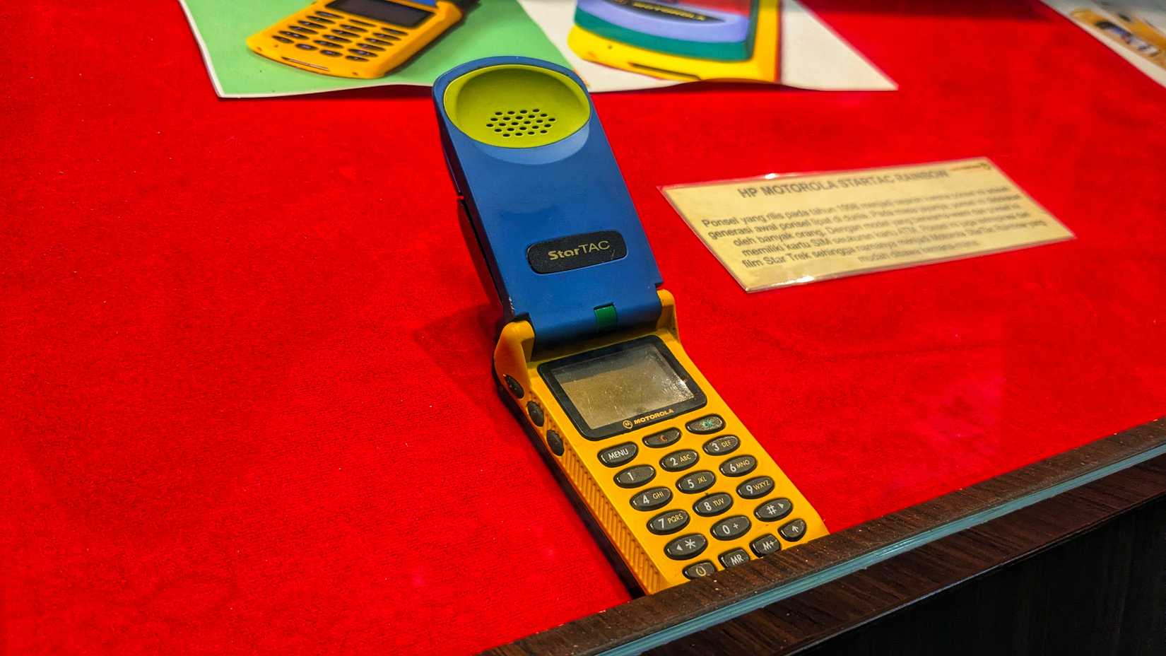 Historic Mobile GSM Motorola Startac photographed on a red background .