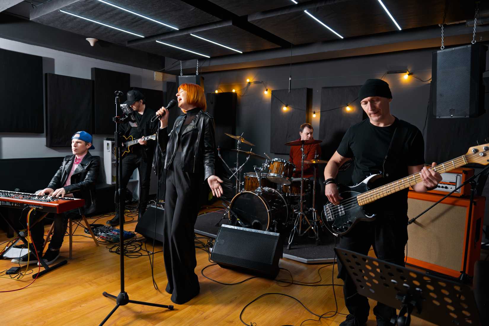 A vibrant music band performs energetically in a studio.