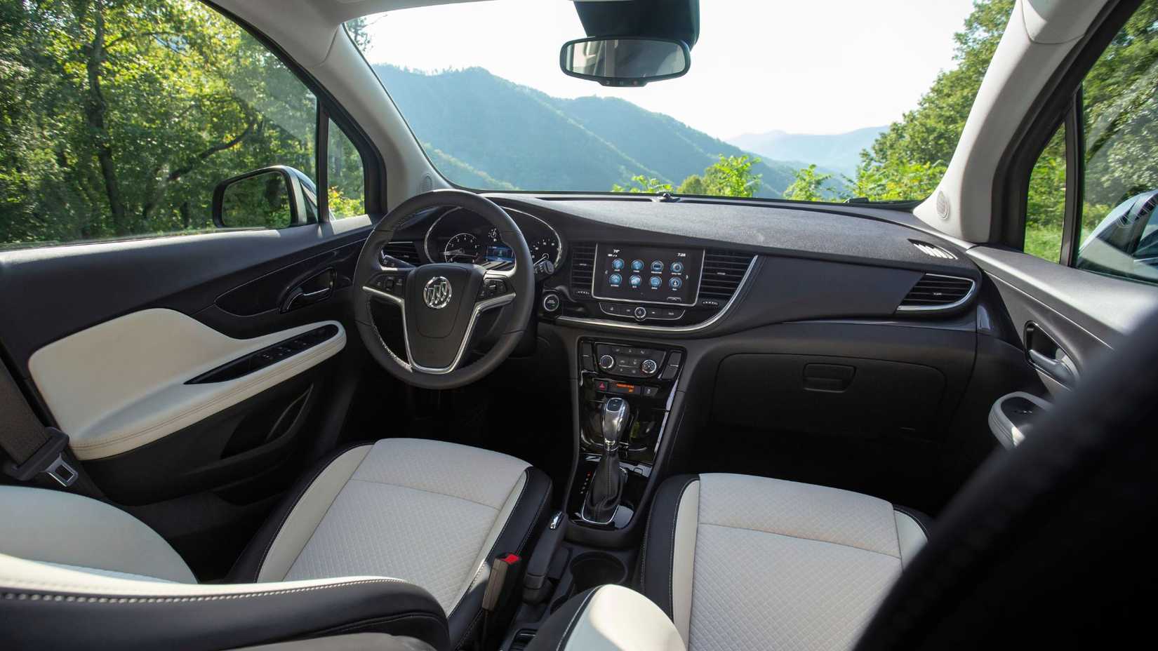 Shot inside the cabin of a 2021 Buick Encore, showing the cream and black leather seats and dashboard.