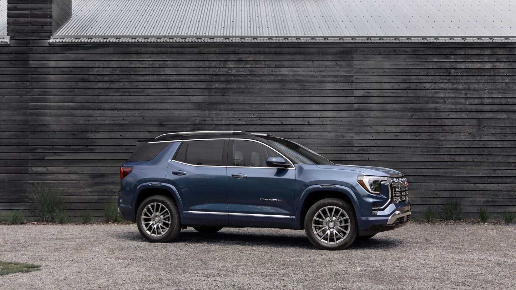 Static side profile photo of a blue 2026 GMC Terrain Denali.