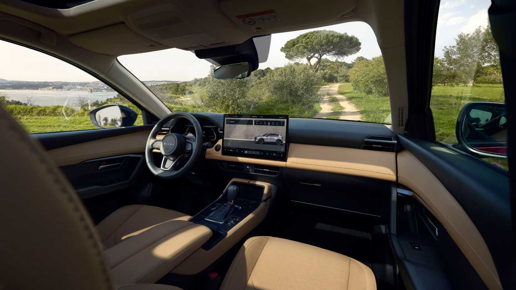 Shot inside the cabin of a 2026 Mazda CX-5, showing the front seats and dashboard.