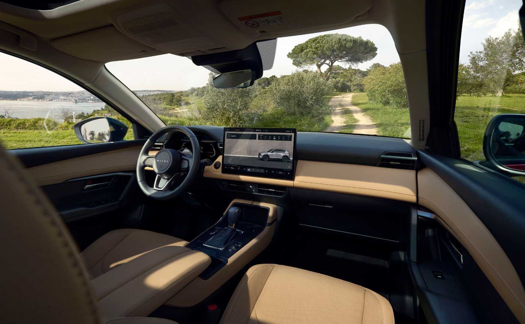 Shot inside the cabin of a 2026 Mazda CX-5, showing the front seats and dashboard.