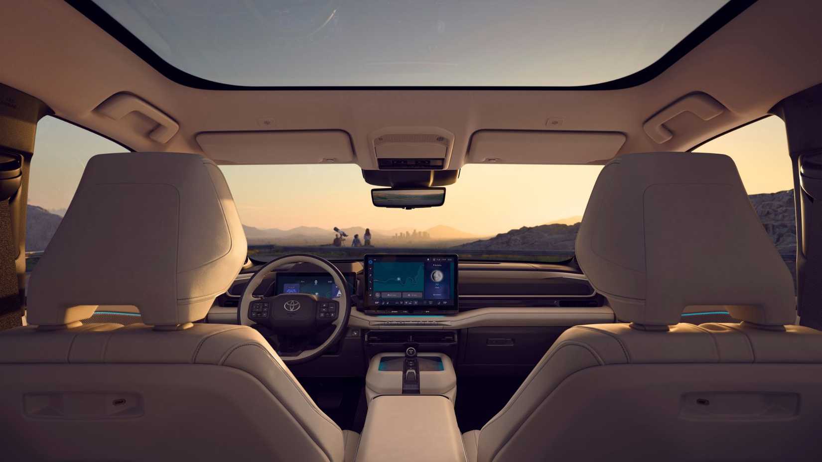 Shot inside the cabin of a 2027 Toyota Highlander Limited, showing the panormaic roof, front seats, and dashboard.