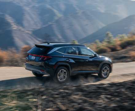 Dynamic rear 3/4 shot of a black 2026 Hyundai Tucson Hybrid.