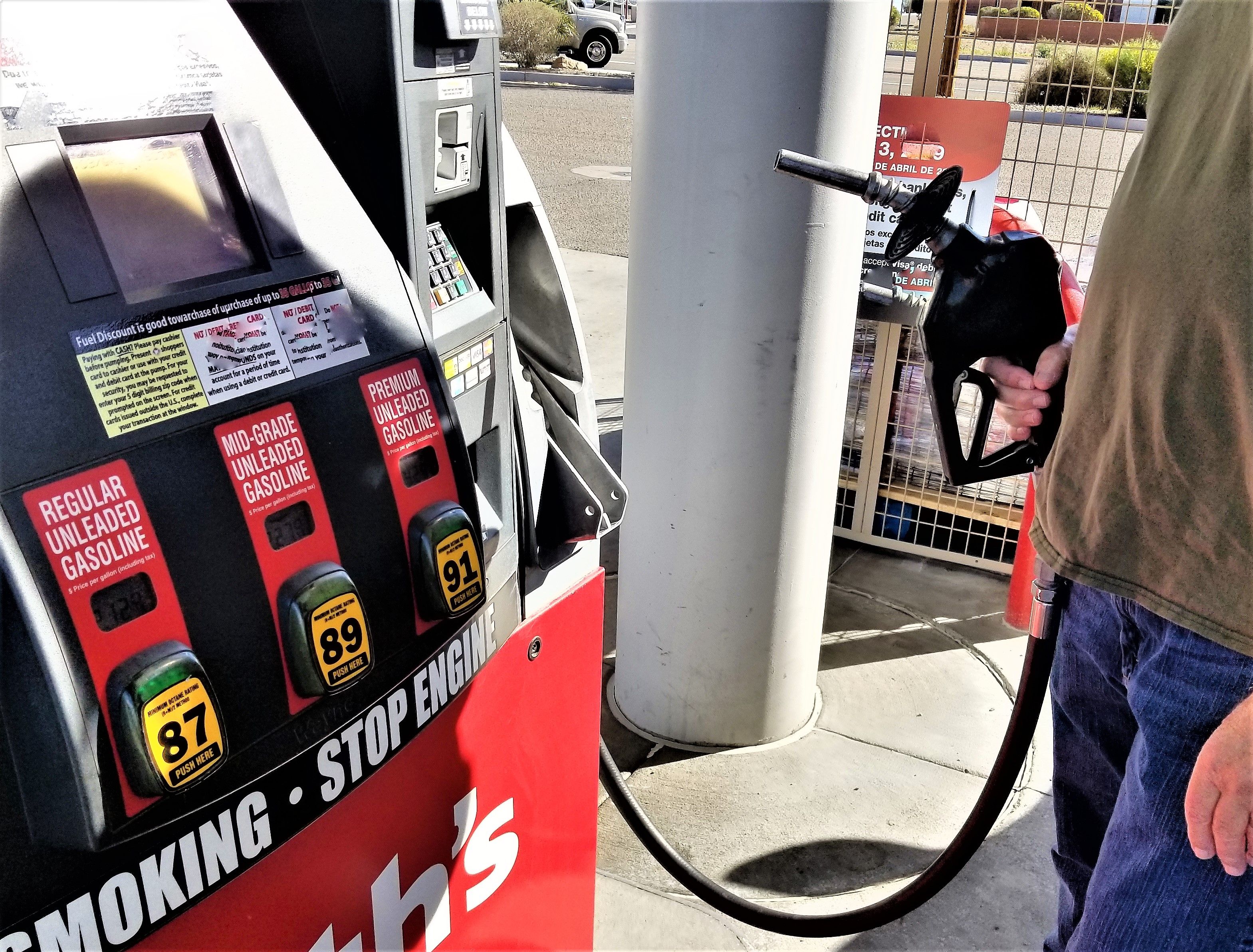 Man standing at a gas pump about to get gas