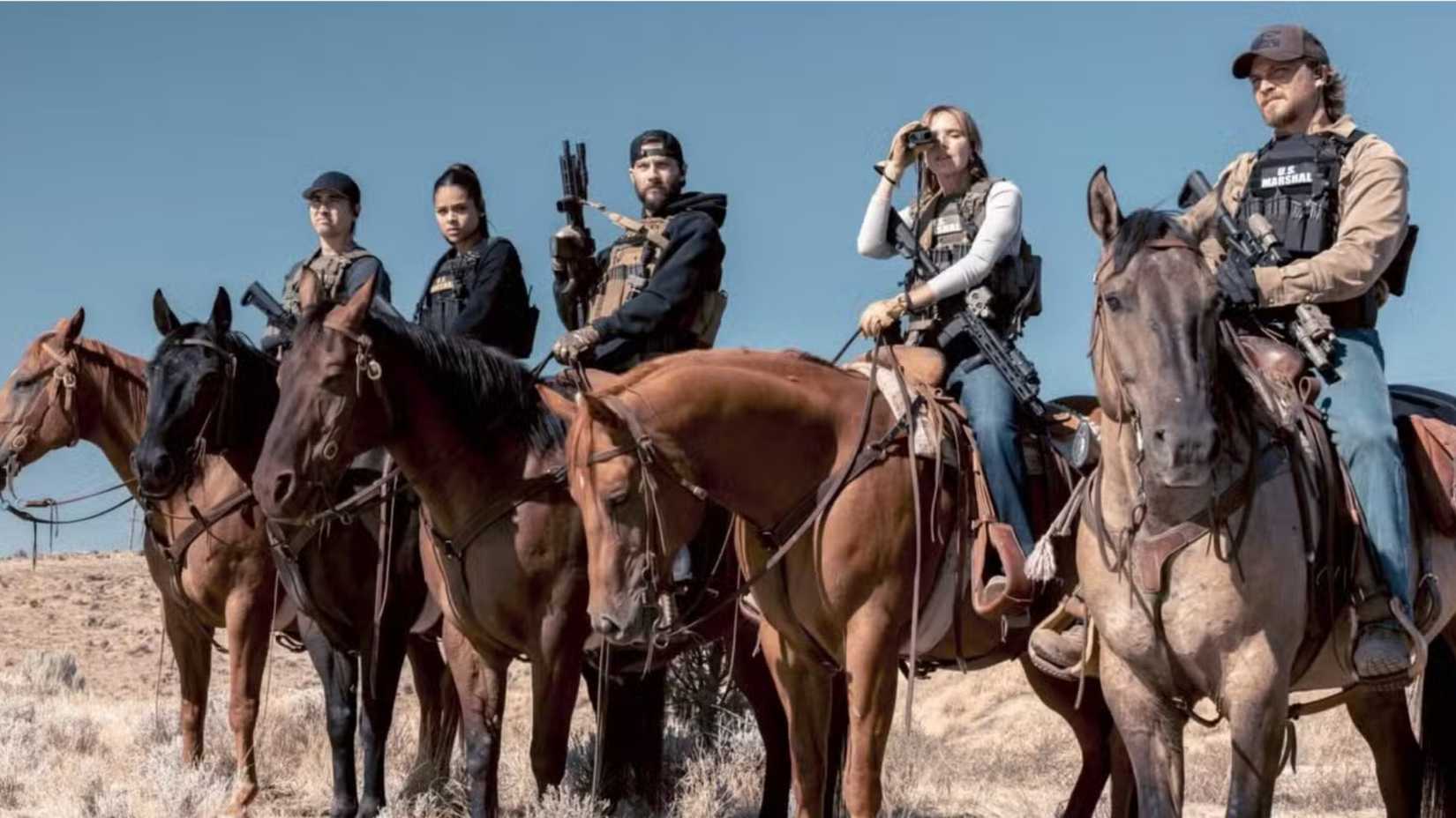Main cast of Marshals sitting on horses, looking out over Montana territory.