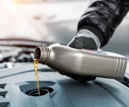 Mechanic adding engine oil