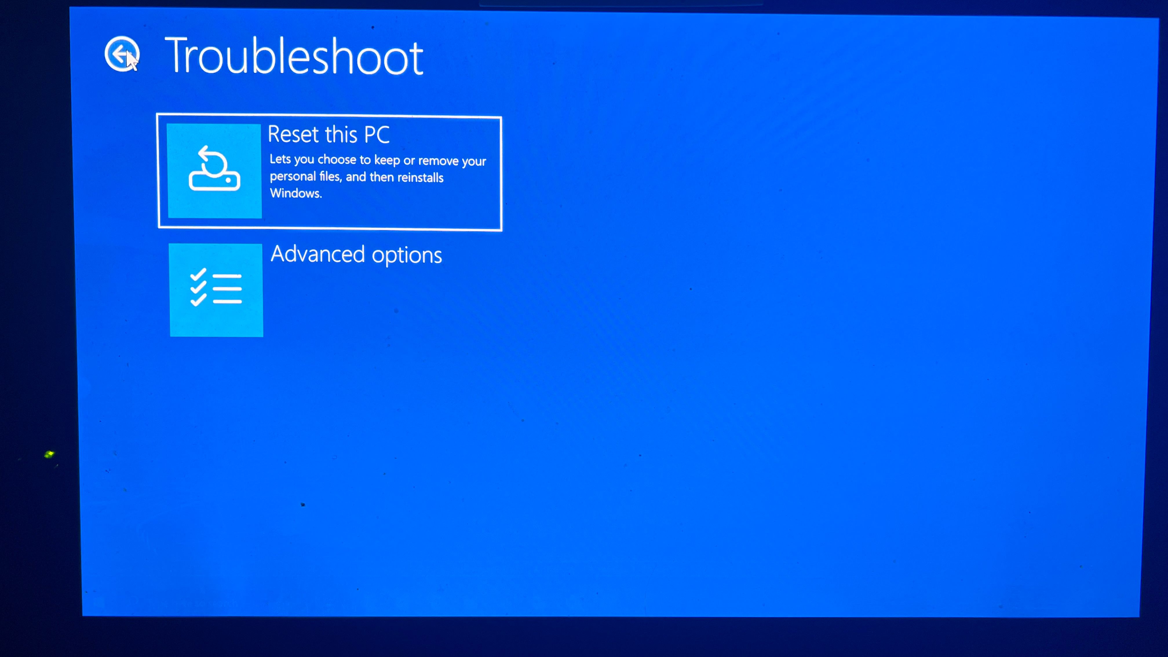 A screenshot of the Windows Troubleshoot dialog with Reset this PC highlighted.