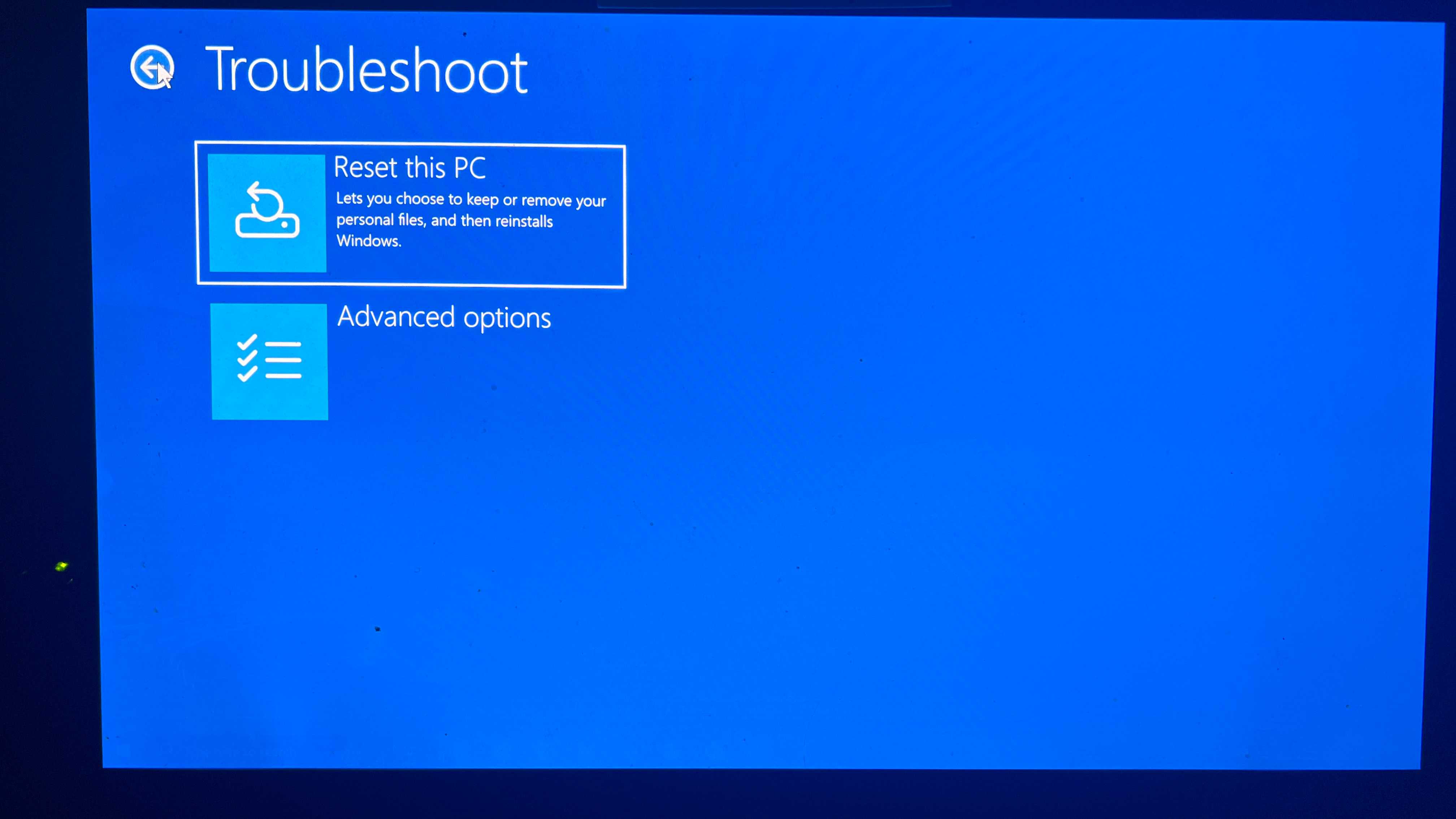 A screenshot of the Windows Troubleshoot dialog with Reset this PC highlighted.