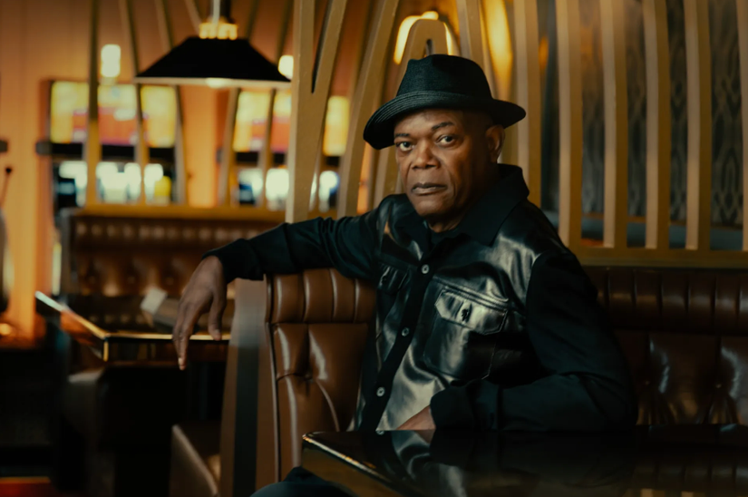 Samuel L. Jackson as Russell Lee Washington Jr. from Tulsa King in a leather coat and black hat, staring at the camera.