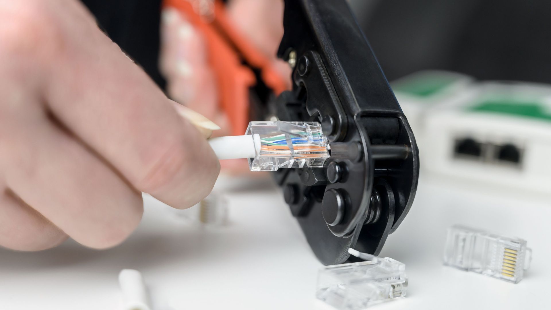 A person has just completed crimping a custom-made Ethernet cable.