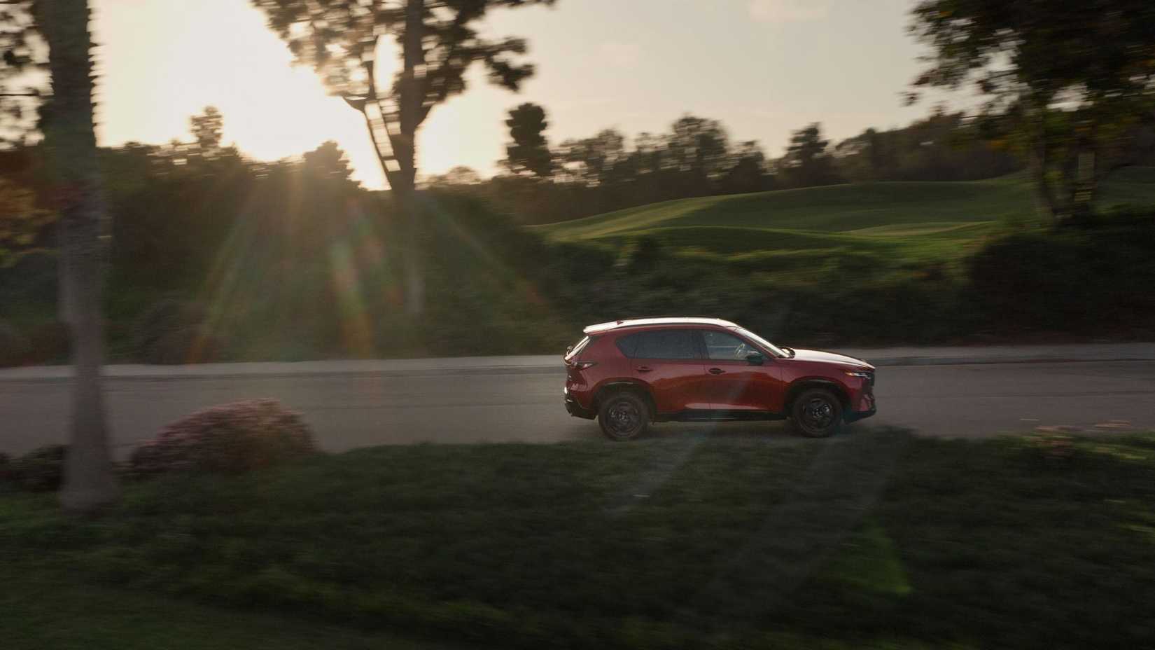 Dynamic side profile shot of a red 2026 Mazda CX-5.