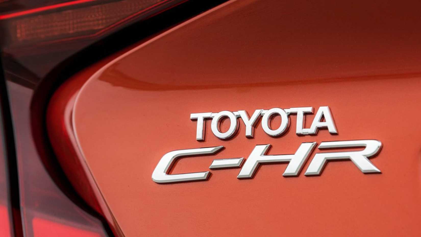 Toma de primer plano de la insignia en la tapa del maletero de un Toyota C-HR 2020 naranja.