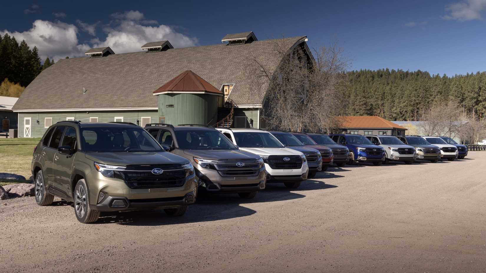 A number of 2025 Subaru Foresters lineup up outside a farm house