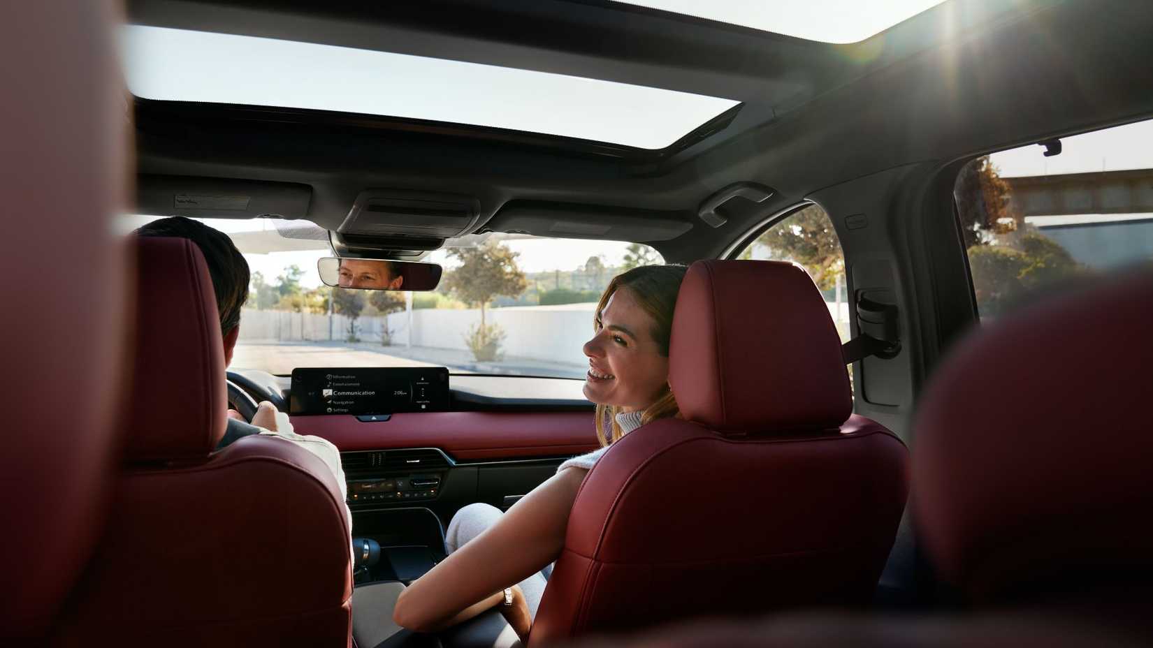 Shot of a female passenger sat in the front passenger seat of a 2026 Mazda CX-70.