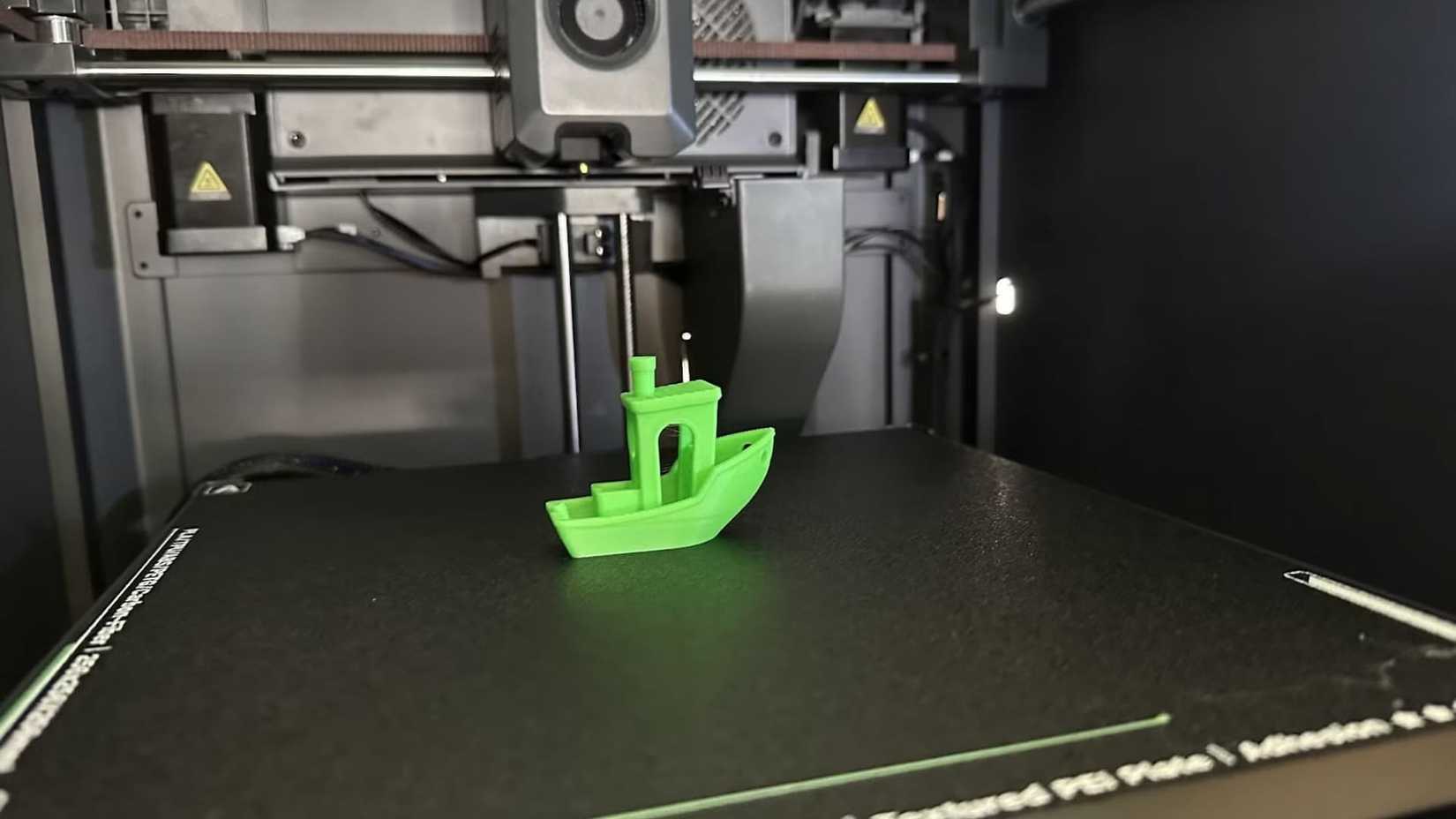 A benchy boat on the print bed of the Elegoo Centauri Carbon.