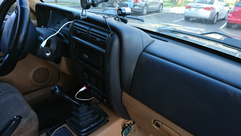 A Raspberry Pi dash camera mounted on the dashboard of a car.