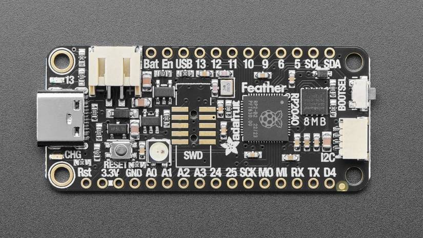 Adafruit Feather RP2040 на чёрном фоне.