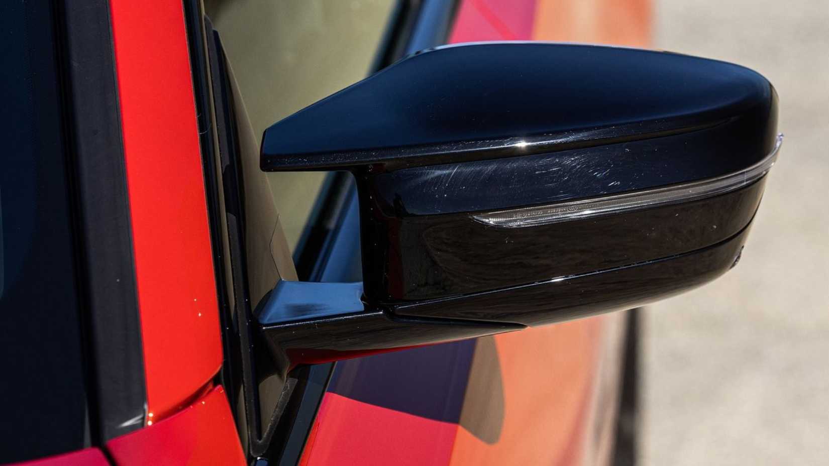 Close-up shot of the black wing mirror on a red 2023 BMW M340i.