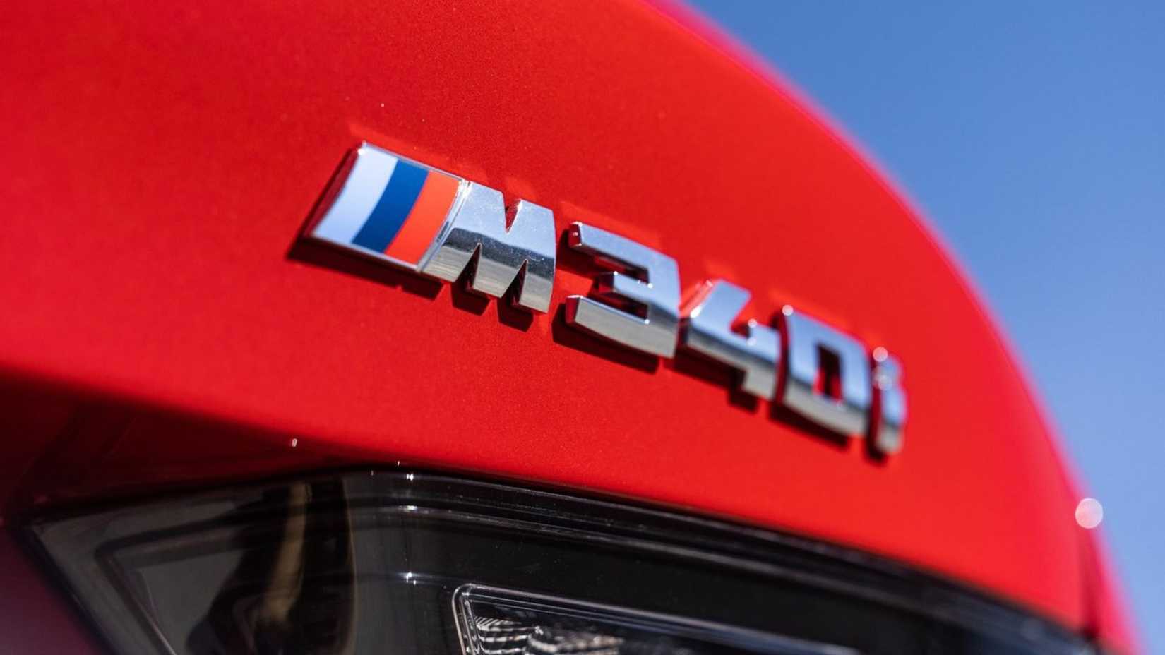 Close-up shot of the badging on the trunk lid of a red 2023 BMW M340i.