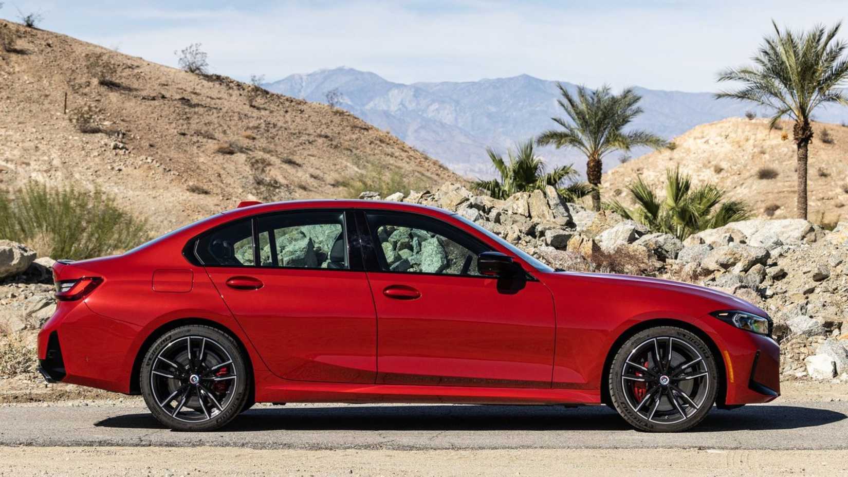 Static side profile shot of a red 2023 BMW M340i.