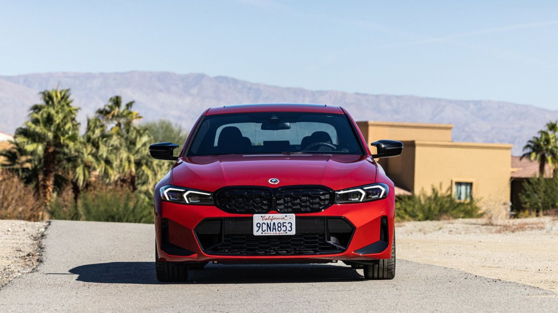 Static front-end shot of a red 2023 BMW M340i.