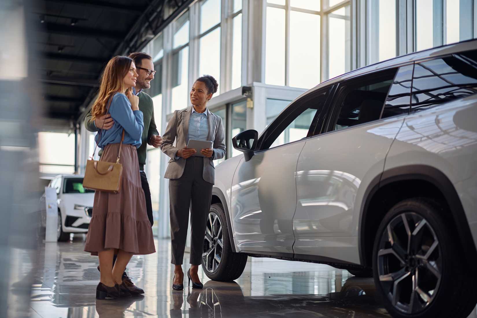 Couple buying a new car on a dealer showroom