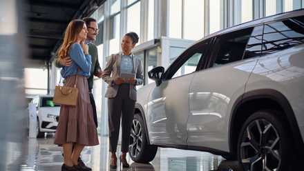 A couple buys a new car at a dealership