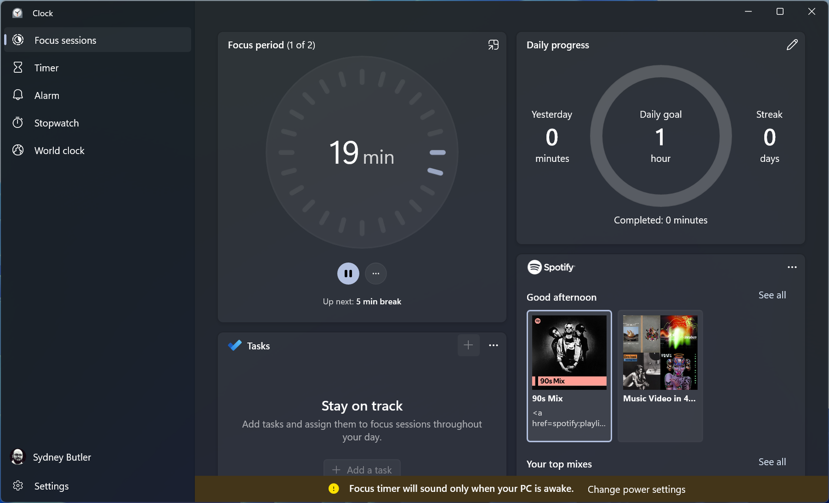 Windows Clock app showing an active Focus session with a 19-minute timer, daily progress stats, task section, and Spotify integration panel.