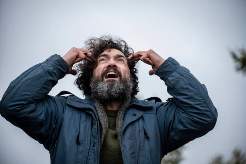 David Alpay as Jade looking fearfully up at the sky in From.