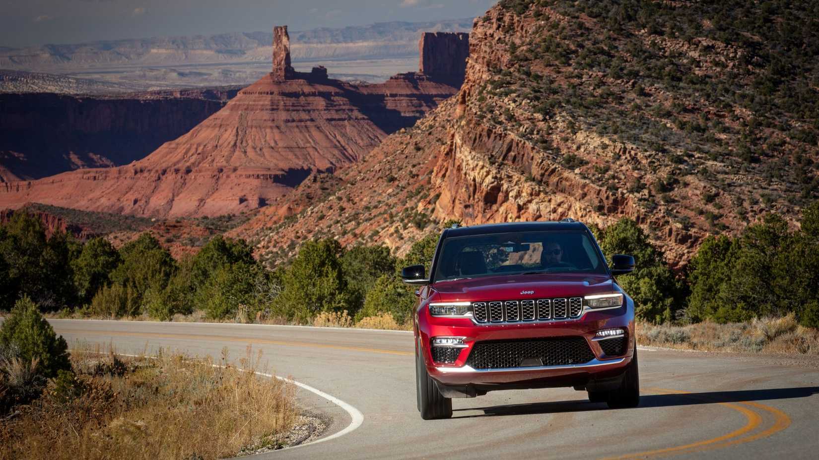 Dynamic front-end shot of a red 2025 Jeep Grand Cherokee Summit Reserve.