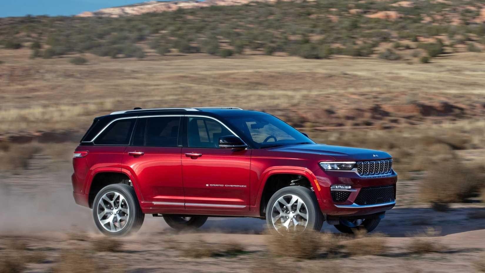 Dynamic side profile shot of a red 2025 Jeep Grand Cherokee Summit Reserve.