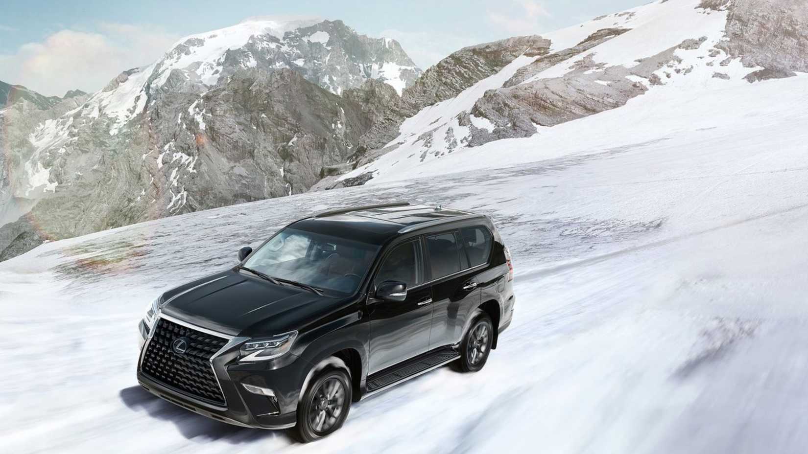 Dynamic front 3/4 shot of a black 2020 Lexus GX 460 driving in the snow.