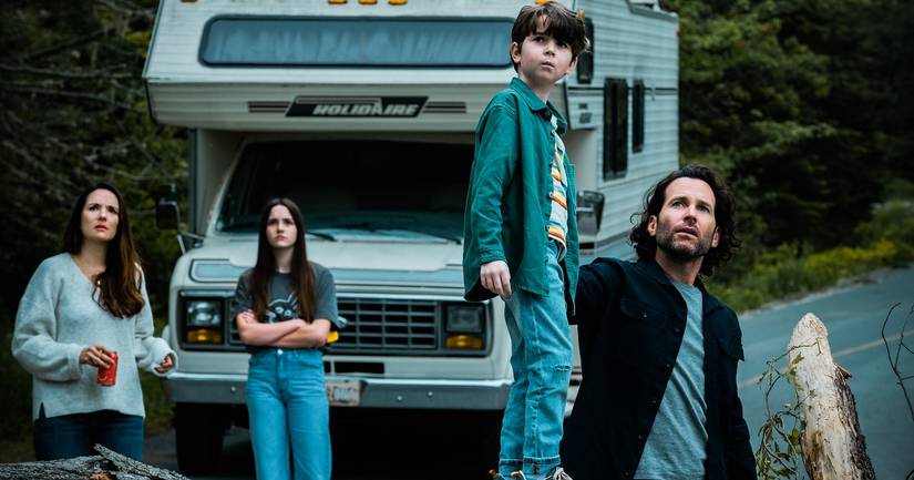 The Matthews family stand in front of their RV looking at the sky in From.