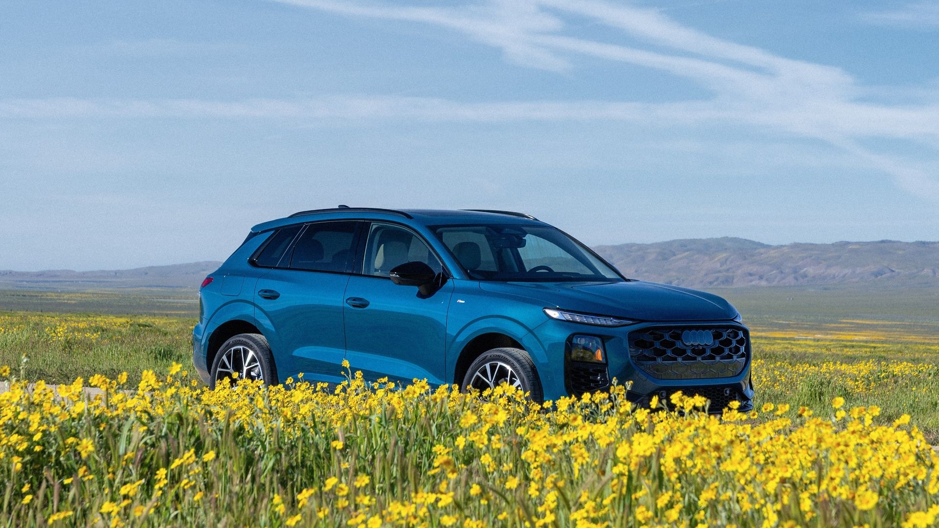 Front 3/4 shot of a 2026 Audi Q3 in a field of flowers