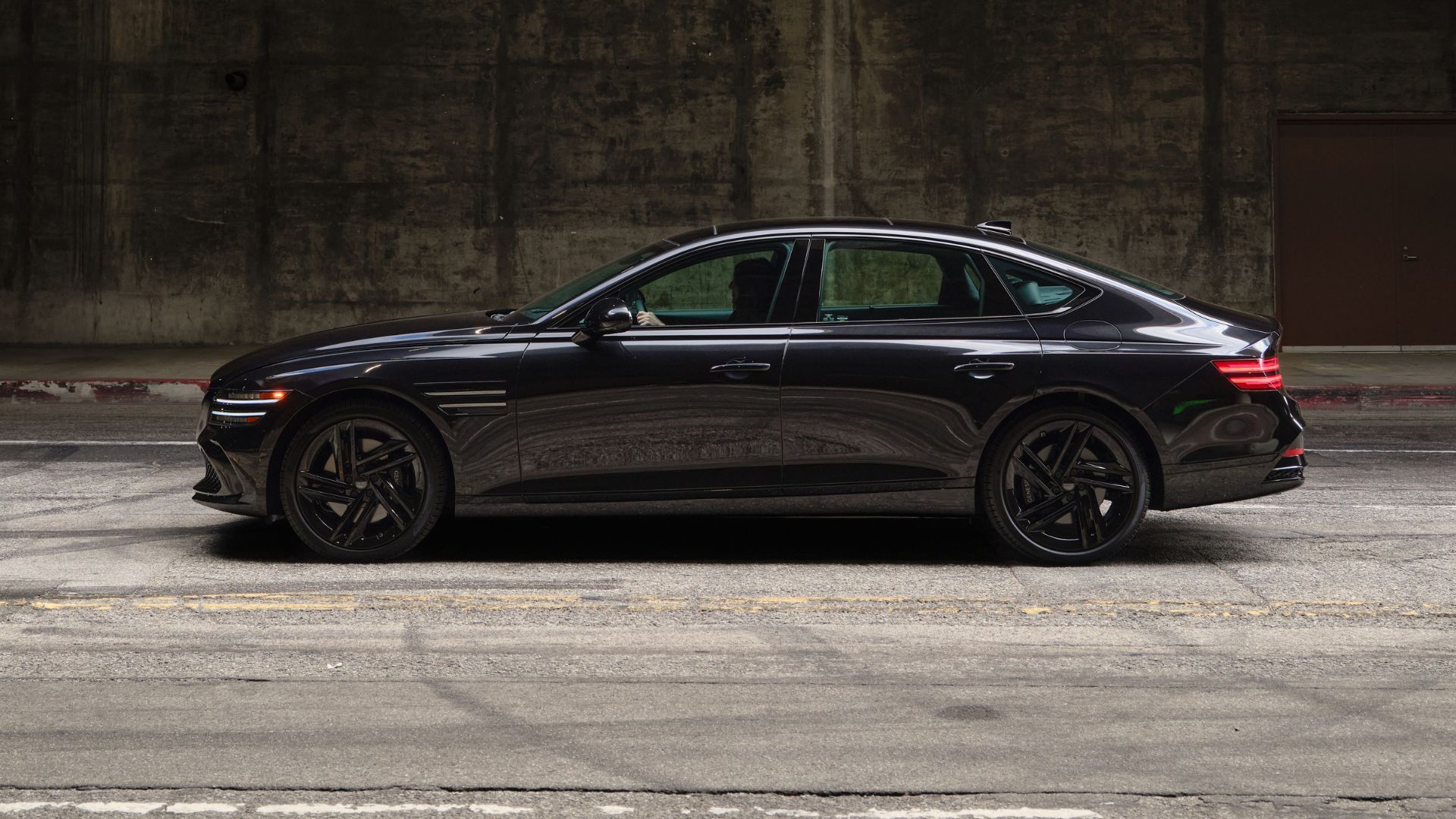 Dynamic side profile shot of a black 2026 Genesis G80 Prestige Black.