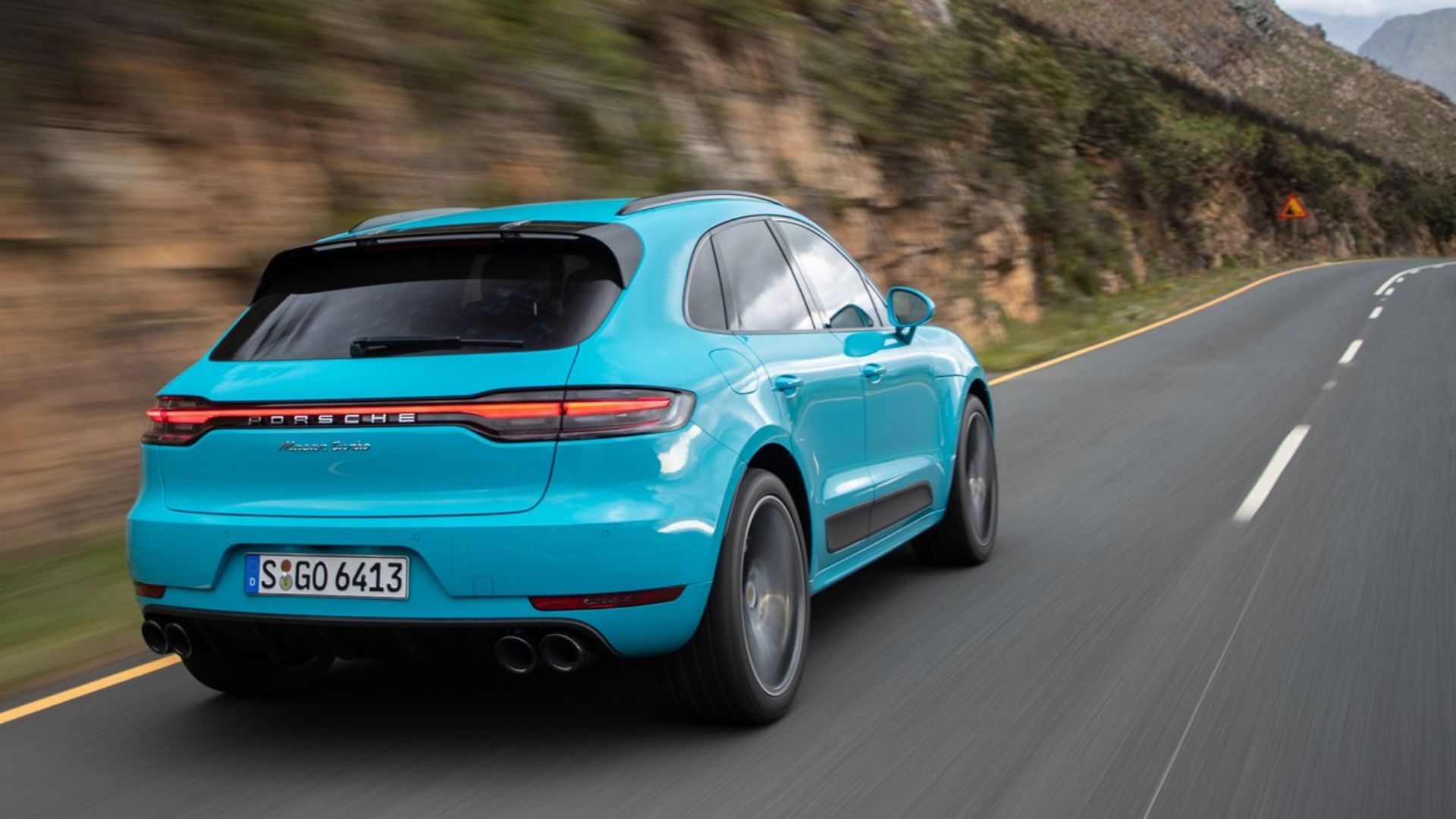 Dynamic rear 3/4 shot of a blue 2019 Porsche Macan Turbo.