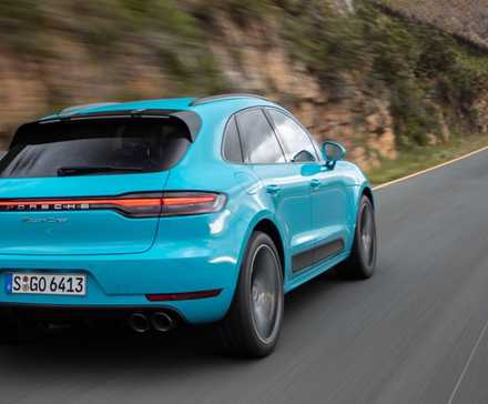 Dynamic rear 3/4 shot of a blue 2019 Porsche Macan Turbo.