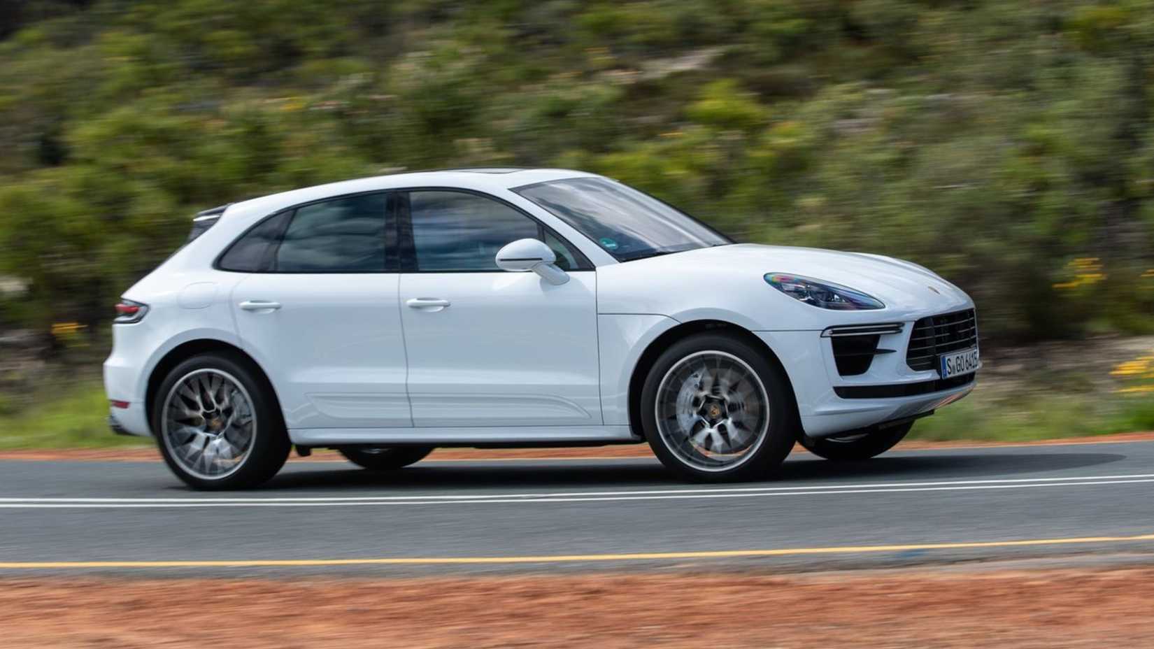 Dynamic side profile shot of a white 2019 Porsche Macan Turbo.