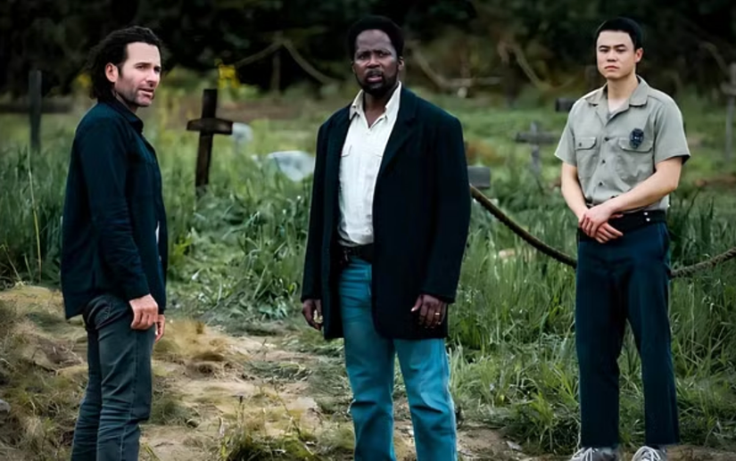 Jim, Boyd, and Kenny stand in a graveyard in From.