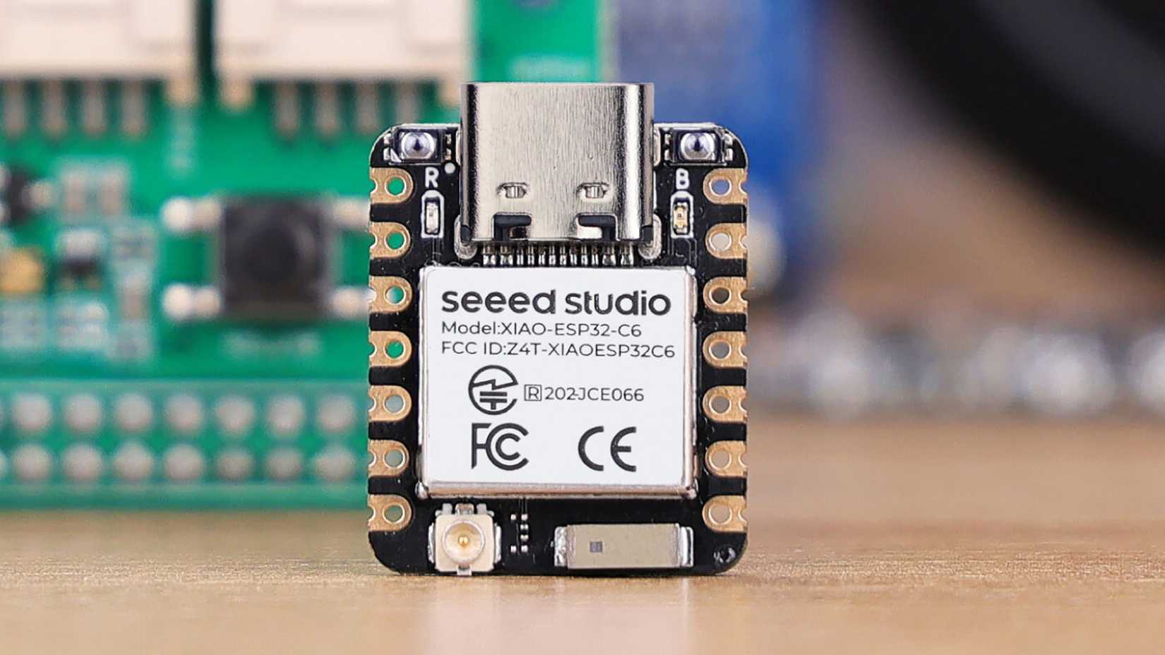 Seeed Studio XIAO ESP32C6 with blurred out microelectronics in the background.