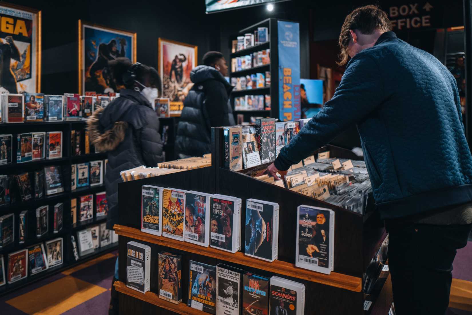 Visitors browsing free DVD and VHS rentals at Kim's Video at Alamo Drafthouse Lower Manhattan.
