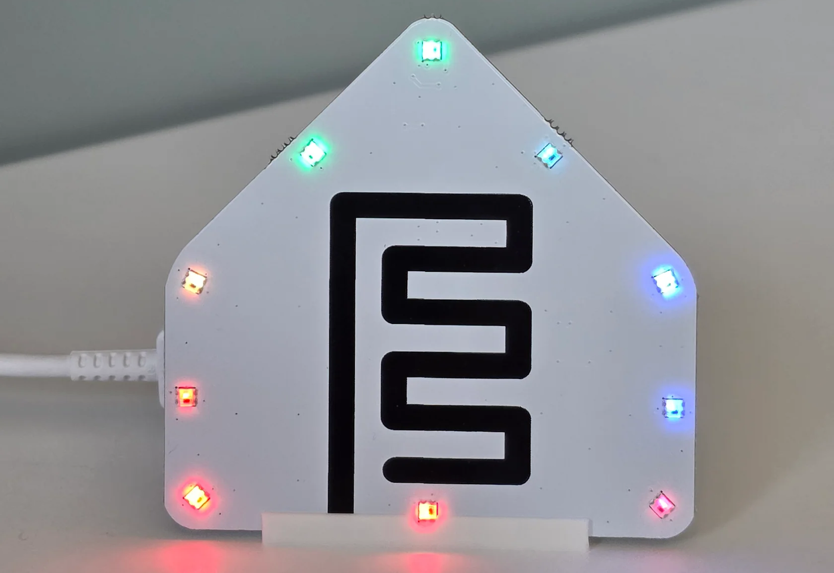 The ESPHome Starter Kit RGB LED and buzzer module on a desk.