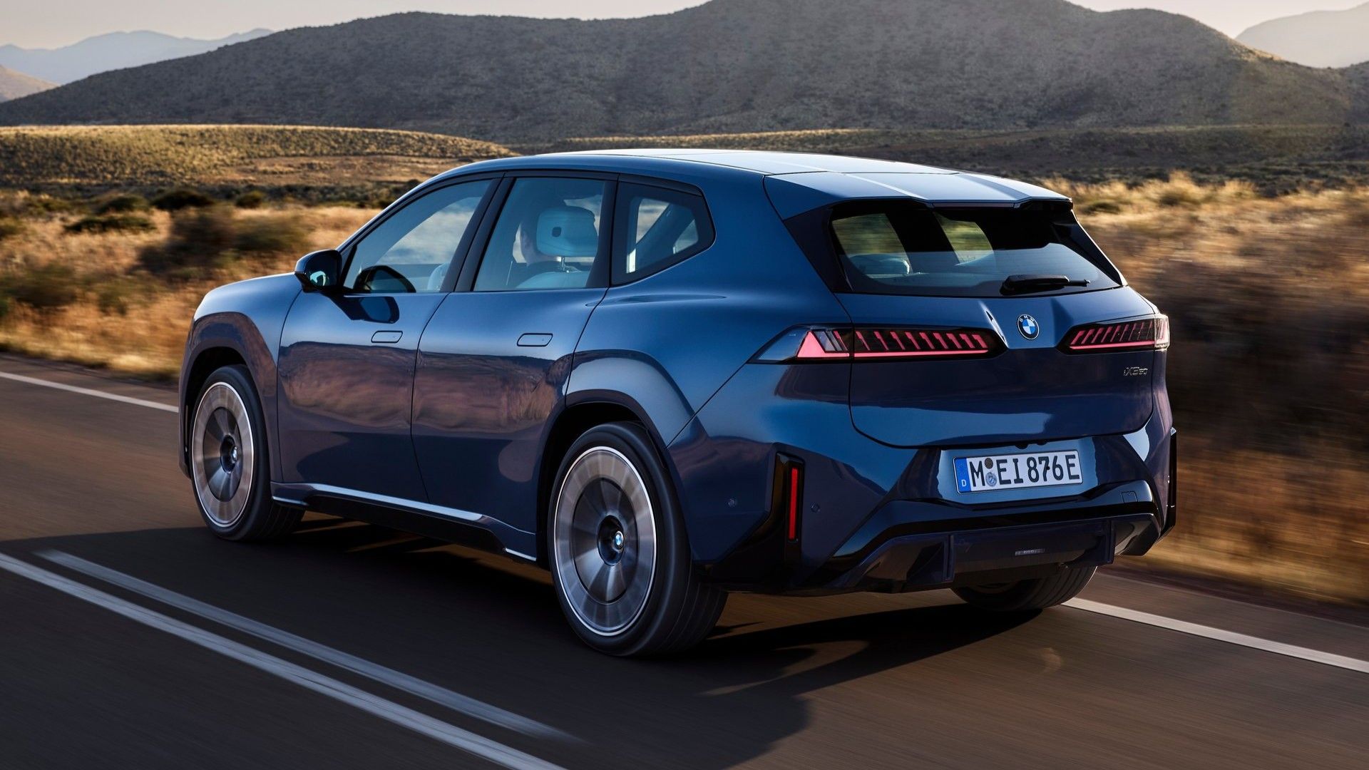 Rear 3/4 action shot of a 2027 BMW iX3