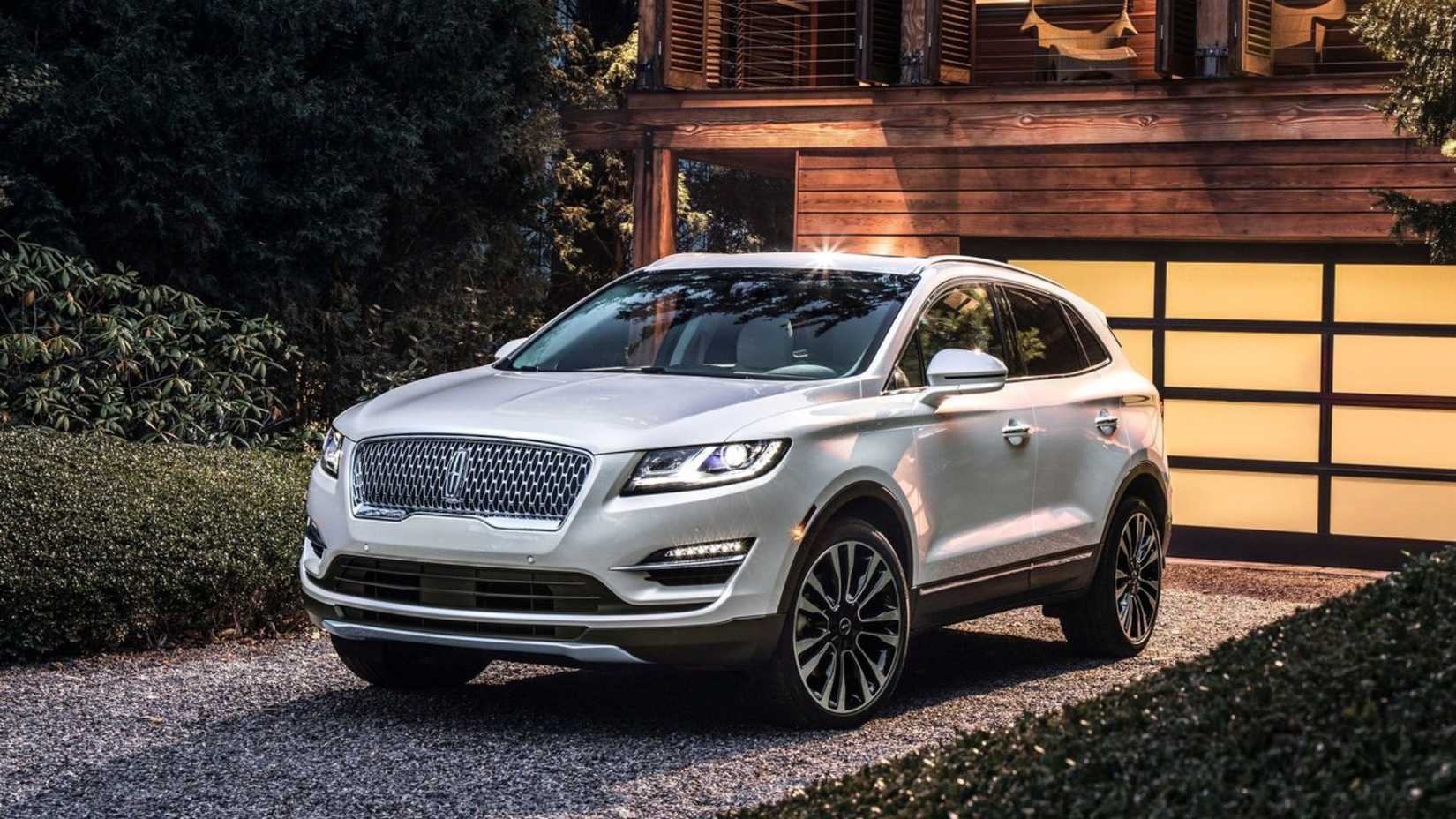 Static front 3/4 shot of a white 2019 Lincoln MKC parked on a driveway.