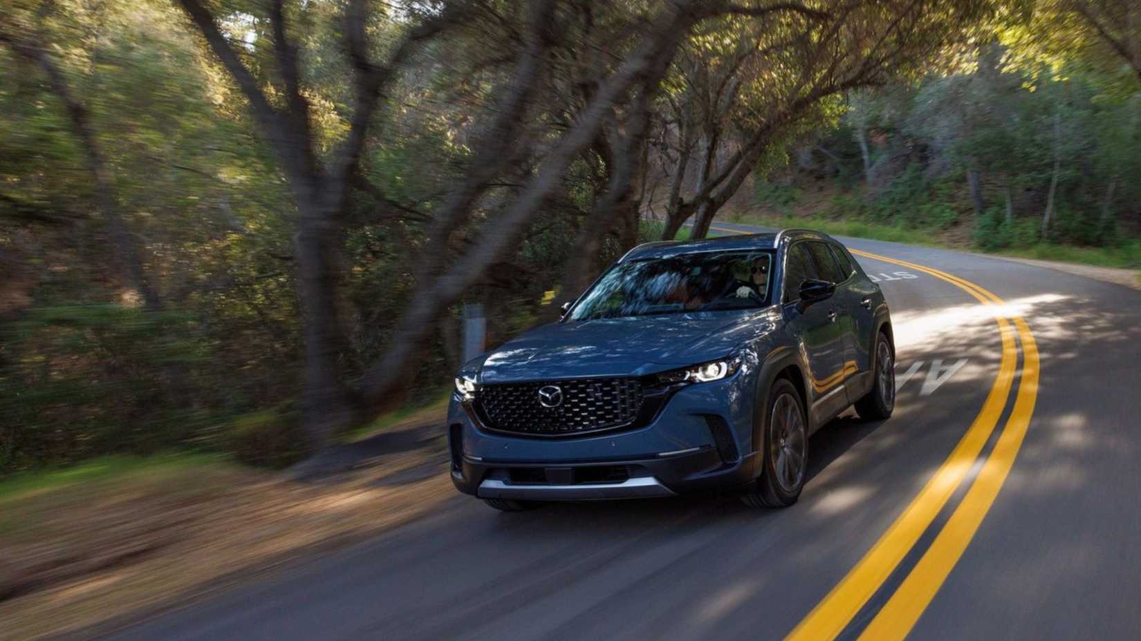青い 2023 マツダ CX-50 のダイナミックな正面 3/4 ショット。