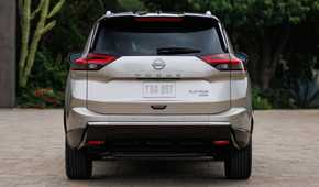 Static rear-end shot of a gold 2024 Nissan Rogue.