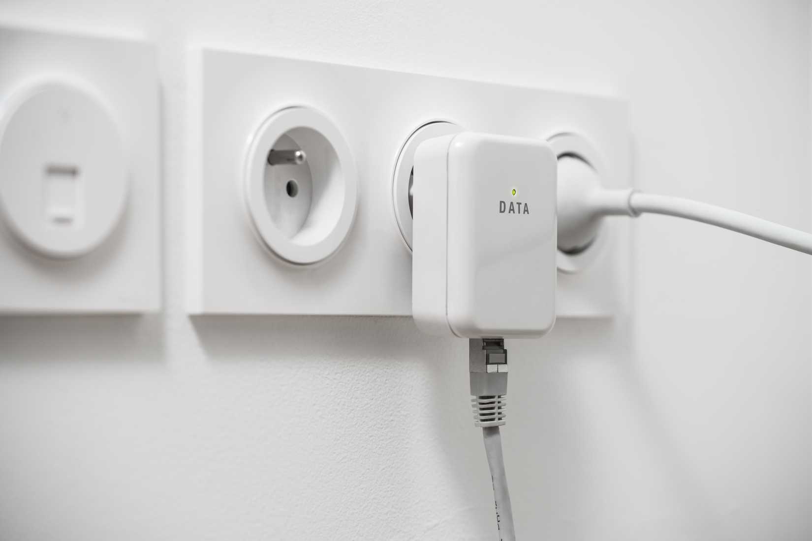 Powerline networking adapter plugged into a wall outlet with an Ethernet cable connected.